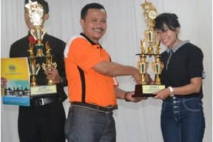 Wakil Rektor Bidang Kemahasiswaan, Dikdik Harjadi saat menyerahkan piala kepada perwakilan paduan suara Uniku.